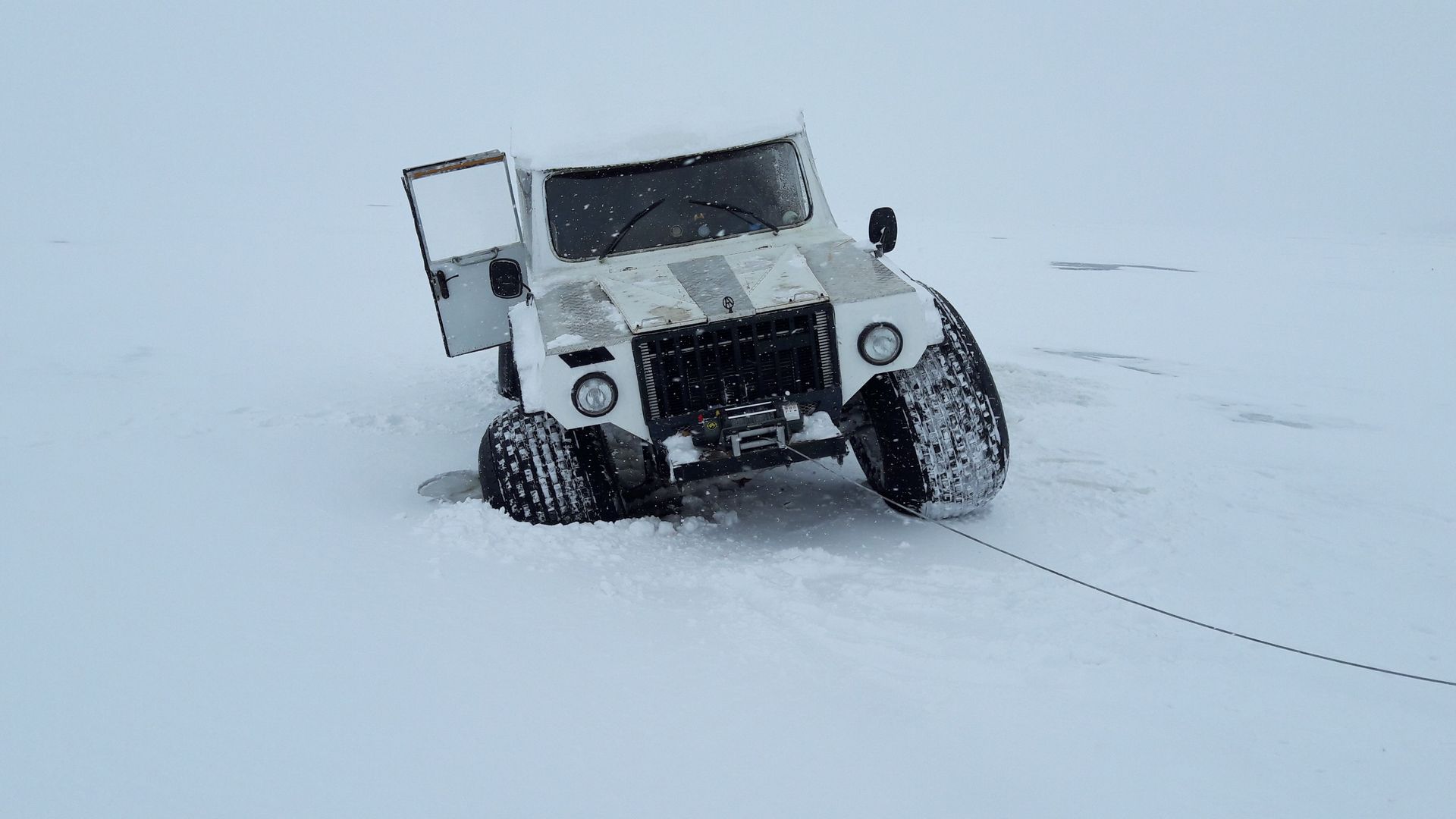 White 4x4 truck traversing snowy landscape in Karelia, Russia, showcasing adventure travel.